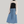 Charger l&#39;image dans la galerie, woman standing in fron of grey backdrop, wearing a beige long-sleeve sweater with thumbholws, black turtleneck paired with a maxi denim blue skirt with drawstrings. also wearing fuzzy socks and blue heels. woman is young, fair skin with black short hair.
